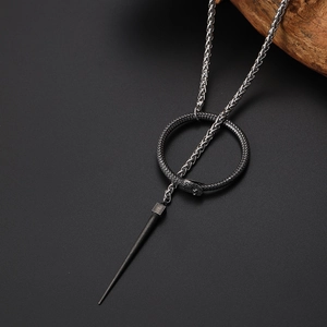 Detail of Ouroboros snake ring and spike pendant on a vintage braided steel chain