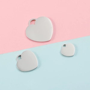 Three polished silver heart pendants in varying sizes on a dual-tone pastel background