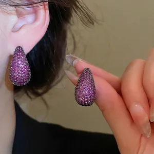 Elegant teardrop stud earrings with pavé-set rose purple zircons on model ear