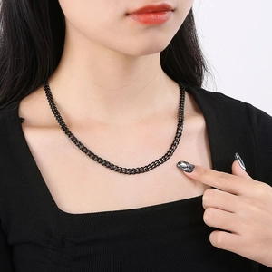 Close-up of black polished stainless steel cuban chain necklace worn by a model