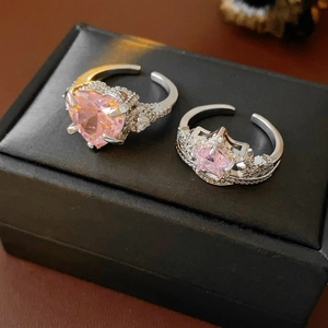 Detail of two adjustable rings featuring pink zircon heart and star crown designs