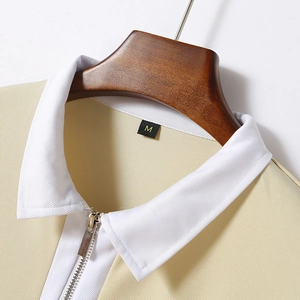 Dettaglio della polo a maniche lunghe color crema con colletto bianco a cerniera lampo