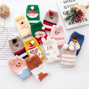 Detailed flat lay of festive coral fleece socks with cute 3D animal and Christmas designs
