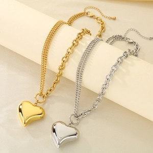 Detailed view of layered gold and silver stainless steel necklaces with heart pendants