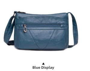Détail de la texture en cuir PU bleu foncé et des poches zippées multicouches du sac