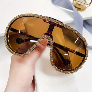 Oversized cycling sunglasses with gold rhinestone edges and amber lenses in a luxury style