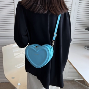 Borsa a tracolla a forma di cuore celeste indossata per mostrare dimensioni e vestibilità