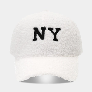 Gros plan de la broderie NY noire sur une casquette de baseball en polaire sherpa blanche