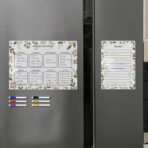 Close-up of magnetic acrylic weekly planner and notes board set on a dark grey refrigerator