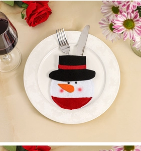 Close-up of a snowman cutlery holder with silver fork and knife on a white plate