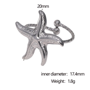 Macro detail of silver starfish open ring with vintage hammered stainless steel texture