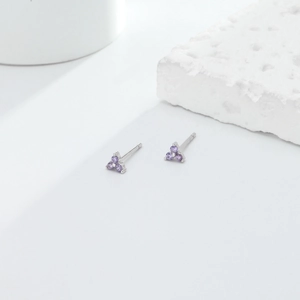 Macro detail of S925 sterling silver triangle studs with purple cubic zirconia stones