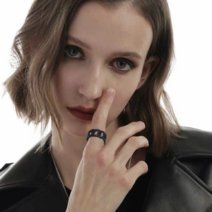 Close-up of black industrial chain link ring in stainless steel worn by a model