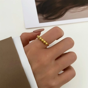 Goldener Anti-Angst-Ring mit drehbaren Perlen am Zeigefinger für Damen getragen