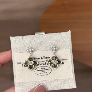 Elegant silver four-leaf clover drop earrings with green zircon and pearl accents