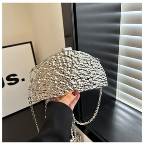 Detail of silver evening clutch bag featuring a hammered metal texture and chain strap