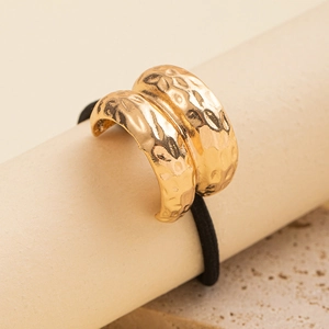 Detail of minimalist gold hammer-textured metal hair tie with high-elastic black cord