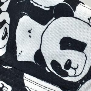 Gros plan détaillé du motif panda sur un chapeau bob réversible en noir et blanc