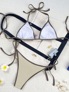 Flat lay detail of two-tone triangle bikini set with earth tones and beach accessories