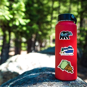 Outdoor camping stickers with bear silhouettes and mountain designs on a red water bottle