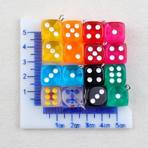 Close-up of colorful acrylic dice pendants with metal loops for DIY jewelry making