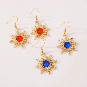 Detailed view of bohemian sunburst earrings featuring red and blue gemstone centers