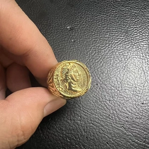 Macro shot of gold Roman coin signet ring featuring embossed Caesar portrait detail