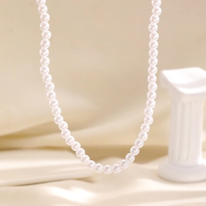 Elegant white imitation pearl necklace detail close-up view showing smooth round beads.