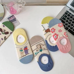 Flat lay of colorful low-cut socks with cartoon jacquard patterns and silicone non-slip grip