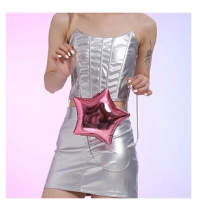 Detail of pink star shaped metallic crossbody bag with silver chain and glossy finish