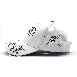 Detail of white baseball cap featuring black graffiti prints and three silver metal rings