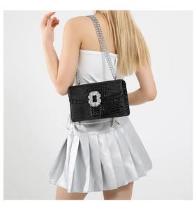 Detail of black crocodile texture bag with rhinestone buckle and silver chain strap