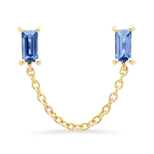 Macro view of gold chain earrings with baguette-cut blue gemstones and modern linked design