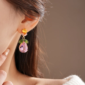 Detail of gold leaf earrings with colorful drop zircon crystals on a model
