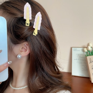 Detail of pink wavy hair clip with Morandi color and elegant pearl stud earrings on model