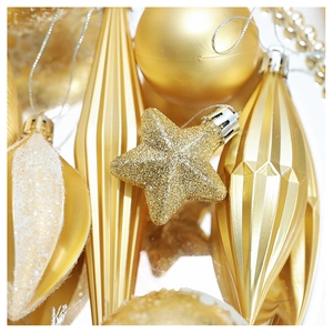Detailed view of assorted gold Christmas ornaments with glitter stars and textured baubles