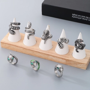 Hip hop style snake rings in stainless steel with colorful eyes on wooden display stand