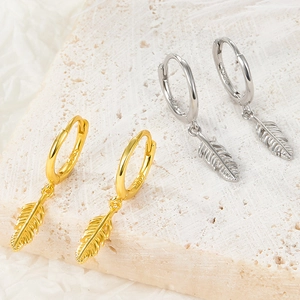 Detail showing S925 sterling silver feather charm hoop earrings in gold and silver finish