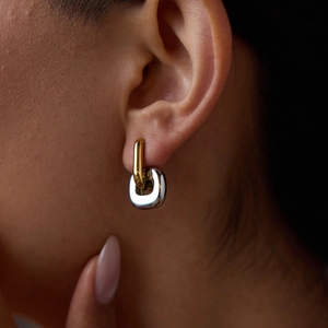 Gros plan de boucles d'oreilles bicolores entrelacées en acier inoxydable géométrique
