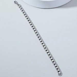 Detail of high-polished stainless steel box chain bracelet featuring a lobster claw clasp