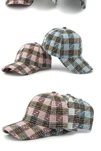 Detailweergave van tweed geruite baseballpetten in roze en blauw met geweven textuur