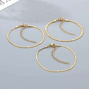 Detail of three gold snake chain bracelets with lobster clasps and adjustable links