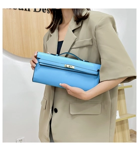 Detail of blue leather handbag with gold metal clasp and top handle for women