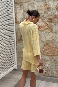 Détail d'un ensemble en tricot jaune clair avec texture crochetée ondulée en V du tissu