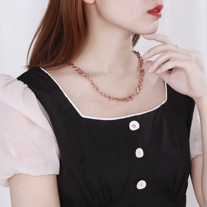 Rose gold infinity symbol necklace in stainless steel worn by a female model
