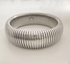Macro shot of silver Tubogas spring bracelet showing polished spiral texture and flexible band