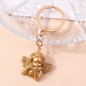 Close-up of golden angel keychain detail playing flute with intricate wing texture