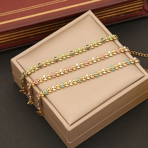 Detailed view of colorful enamel wheat ear bracelets on a beige leather jewelry box