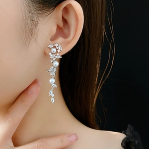 Detail von silbernen Perlenohrringen mit Zirkonia-Ähren, am Model präsentiert