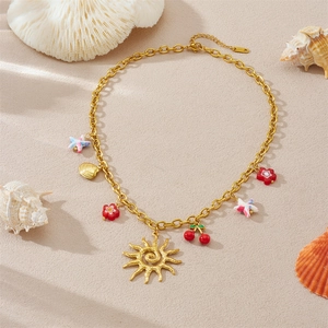 Collier en acier inoxydable doré avec pendentifs soleil, cerise et étoile de mer sur sable